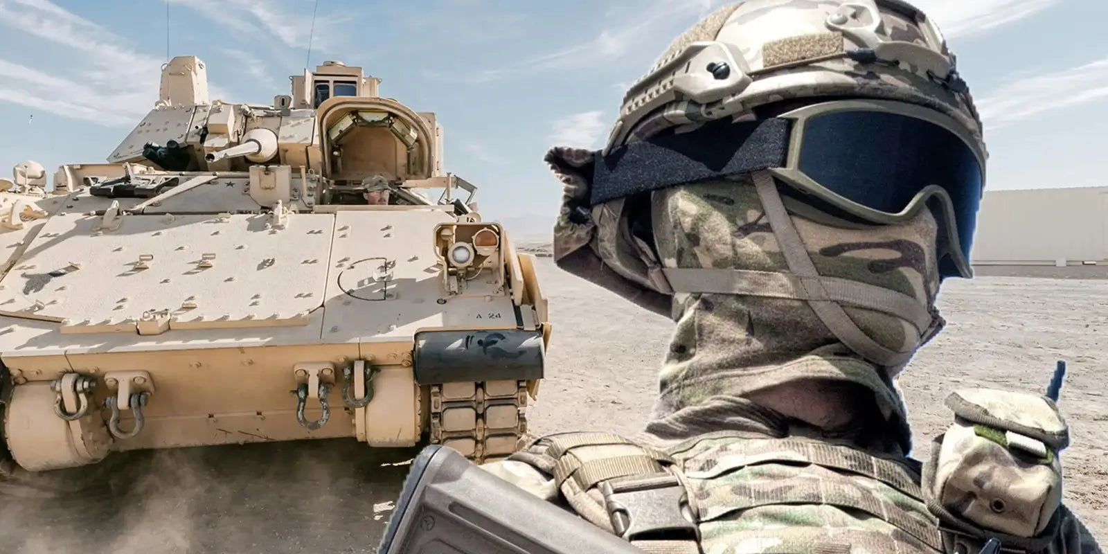 Soldat en tenue de camouflage intégrale avec une cagoule militaire, un casque tactique et lunettes, posant devant un véhicule blindé beige dans un environnement désertique.
