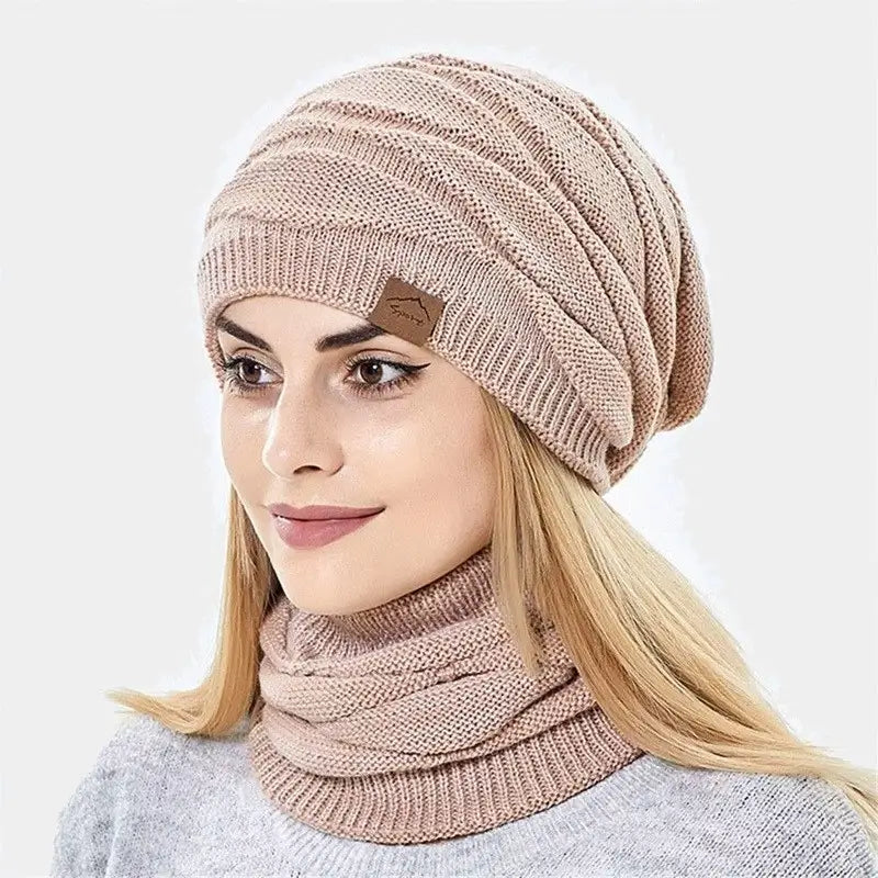 Frau trägt eine rosa 2-in-1-Sturmhaube, die Kopf und Hals mit einem weichen und eleganten Strickmuster bedeckt.