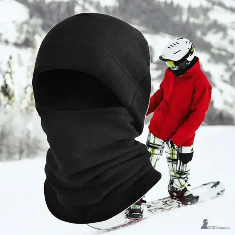 Bonnet cagoule black porté en montagne enneigée, snowboarder en arrière-plan, accessoire chaud pour activités hivernales Espace Cagoules