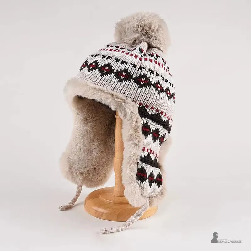 Grauer Hut mit schwarzen und roten Mustern, Pompon und beigem Kunstpelz gefütterter Innenseite