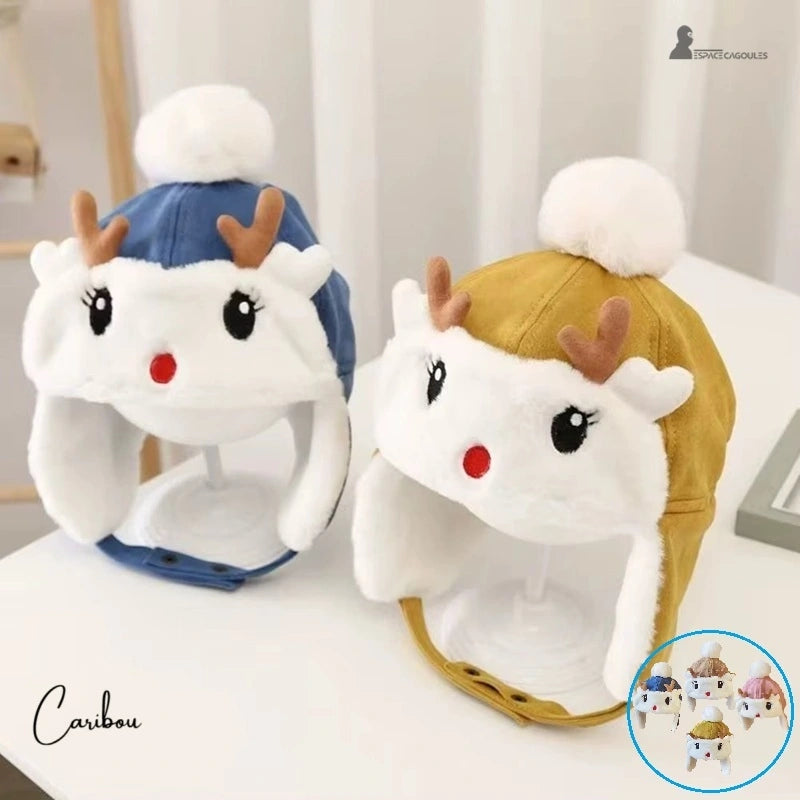 Blue and yellow fleece reindeer children's hat with ears and white pompom, placed on a bright indoor stand