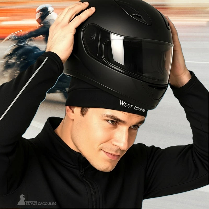 Bonnet sous Casque moto été noir porté par un motard mettant un casque intégral noir en arrière-plan urbain dynamique