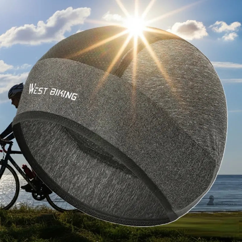 Bonnet sous casque vélo été gris en soie glacée présenté sous le soleil avec cycliste en arrière-plan - Espace Cagoules