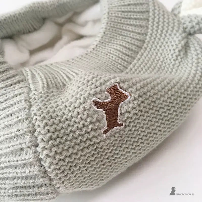 Cagoule Bébé 6 à 36 mois tricotée grise avec broderie chien marron sur le côté, détail proche mettant en valeur la finition douce et de qualité