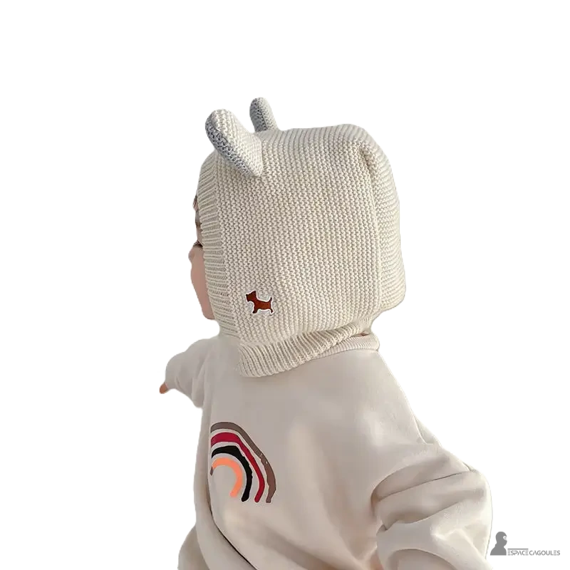 Cagoule Bébé 6 à 36 mois beige avec oreilles tricotées grises, vue de profil portée par un enfant, broderie chien marron visible sur le côté