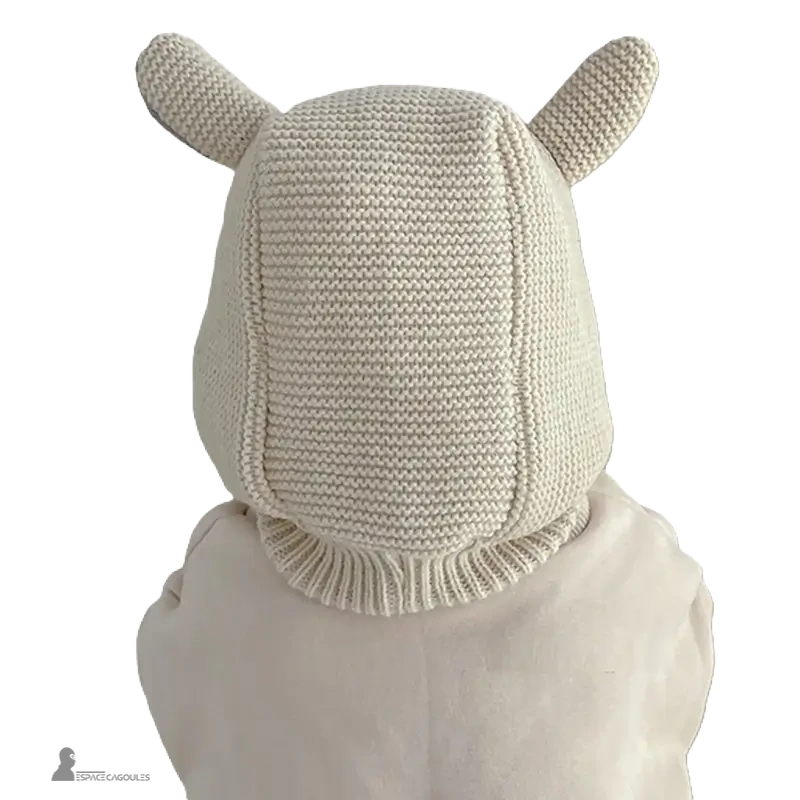 Cagoule Bébé 6 à 36 mois tricot beige vue de dos portée par un enfant, oreilles tricotées en relief, maille épaisse et couvrante pour l’hiver