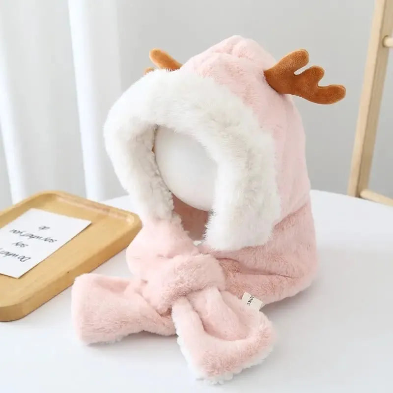 Cagoule bébé fille rose avec des cornes de cerf en fausse fourrure moelleuse, placée sur un mannequin en intérieur. L’intérieur est doublé pour plus de chaleur, avec une dentelle en arrière-plan.