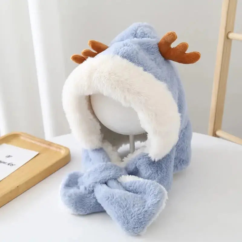 Baby-Sturmhaube für Jungen aus blauem Fleece mit weißem Futter und kleinen braunen Rentierhörnern, ausgestellt auf einer Schaufensterpuppe im Innenbereich, mit hellem Hintergrund und einem hellen Holztisch.