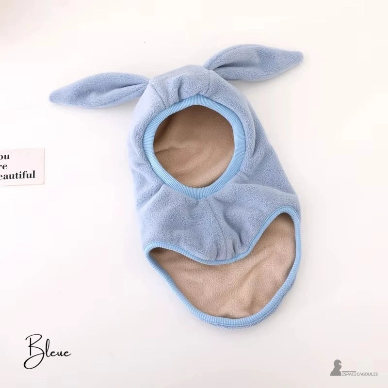 Cagoule bĂ©bĂ© polaire bleue avec des oreilles de lapin, parfaite pour garder la tĂȘte et le cou bien au chaud en hiver. IntĂ©rieur doublĂ© en tissu doux.