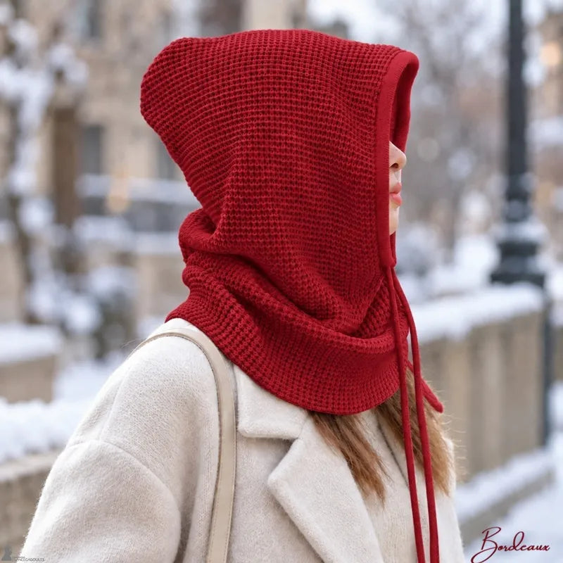 Femme de profil portant la cagoule cache cou bordeaux capuche relevée sous la neige - Espace Cagoules