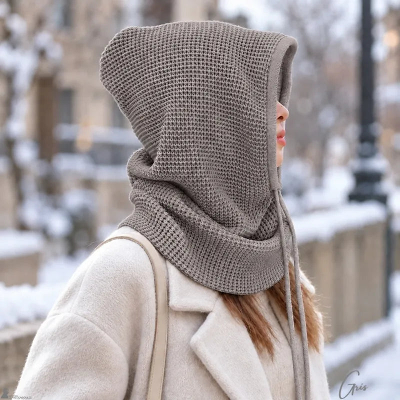Femme de profil portant la cagoule cache cou grise capuche relevée dans un décor enneigé - Espace Cagoules
