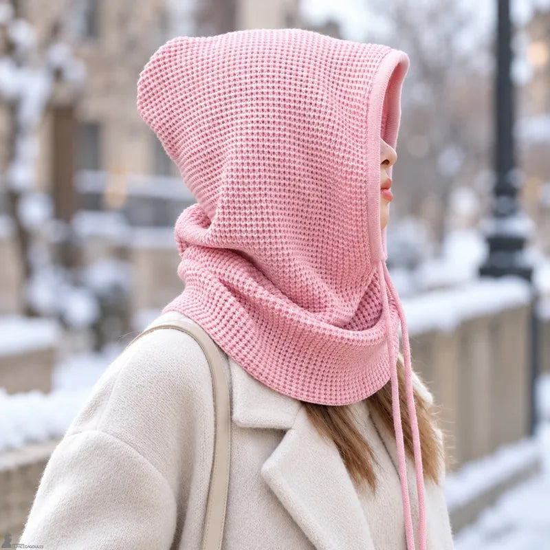 Femme de profil portant la cagoule cache cou rose poudré capuche relevée en extérieur hivernal - Espace Cagoules