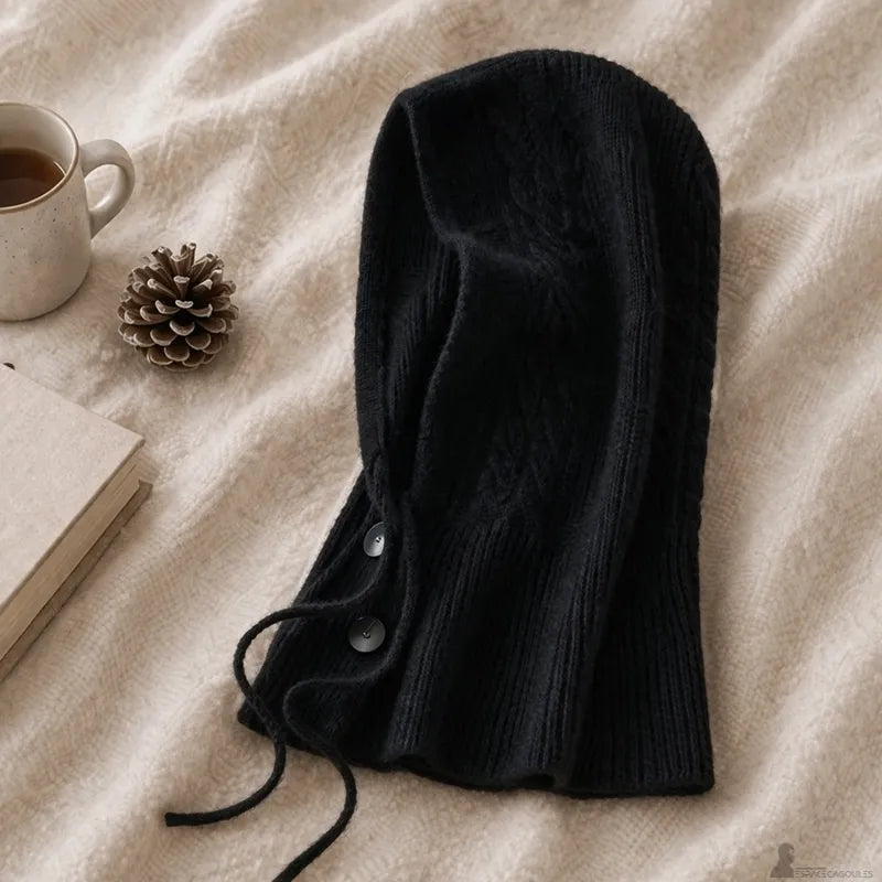 Vue produit cagoule en cachemire pour femme noire posée à plat avec texture maille et cordons pendants - Espace Cagoules