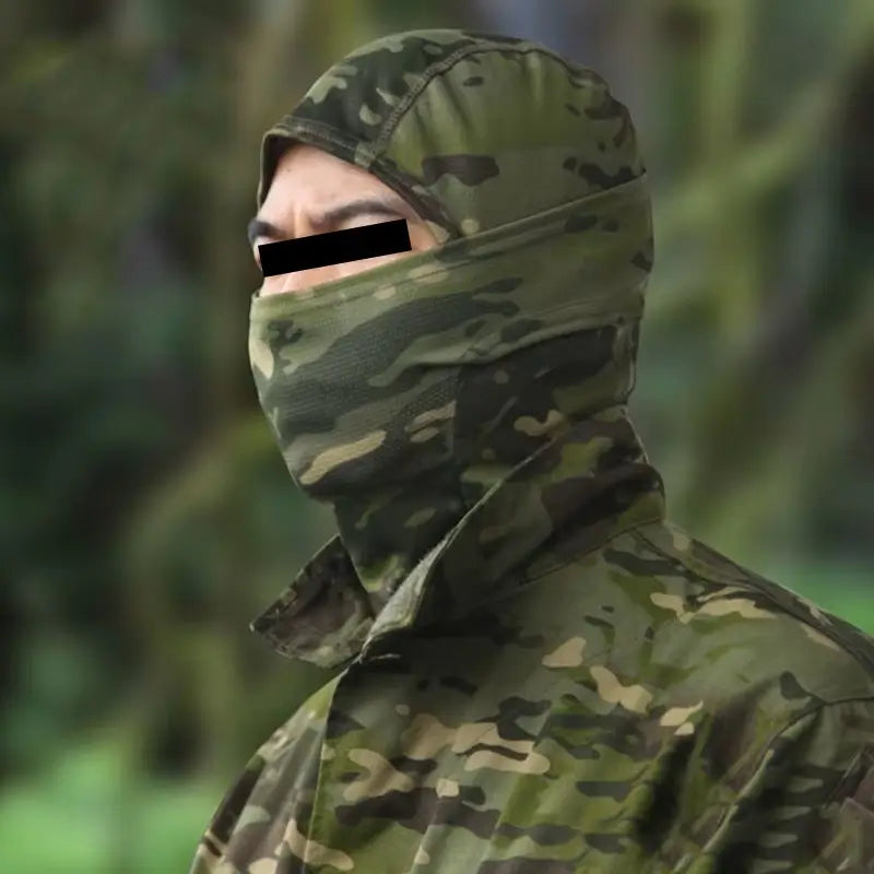 Homme équipé d’une cagoule camouflage verte et marron, recouvrant la tête et le cou, évoluant discrètement dans un environnement boisé, idéale pour la chasse et l’infiltration en airsoft.