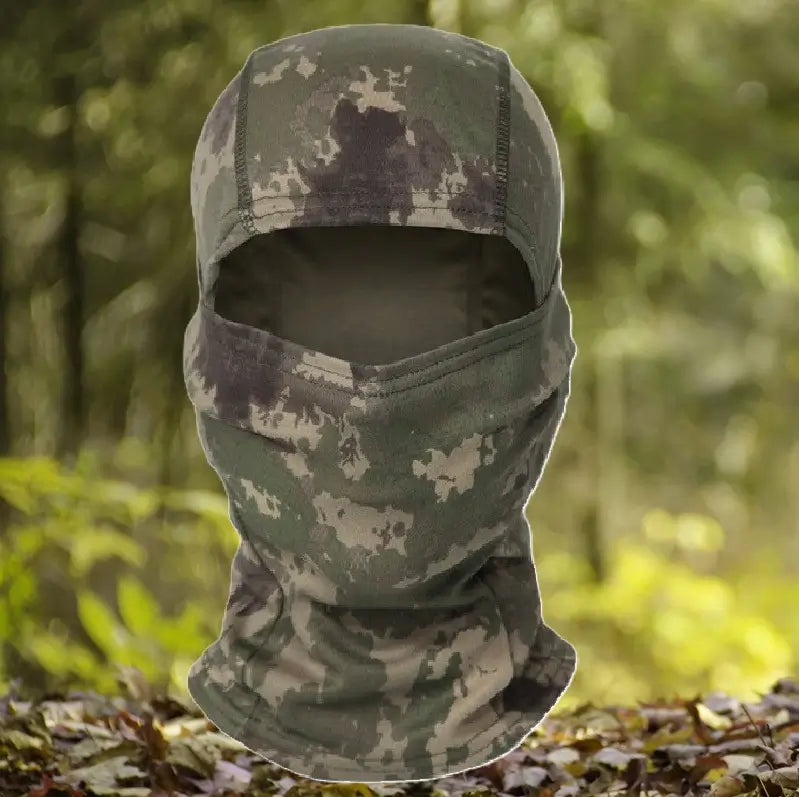 Hood-camouflage-military in shades of green and brown, offering full coverage of the face and neck, ideal for outdoor activities such as hunting or airsoft, presented in a forest environment.