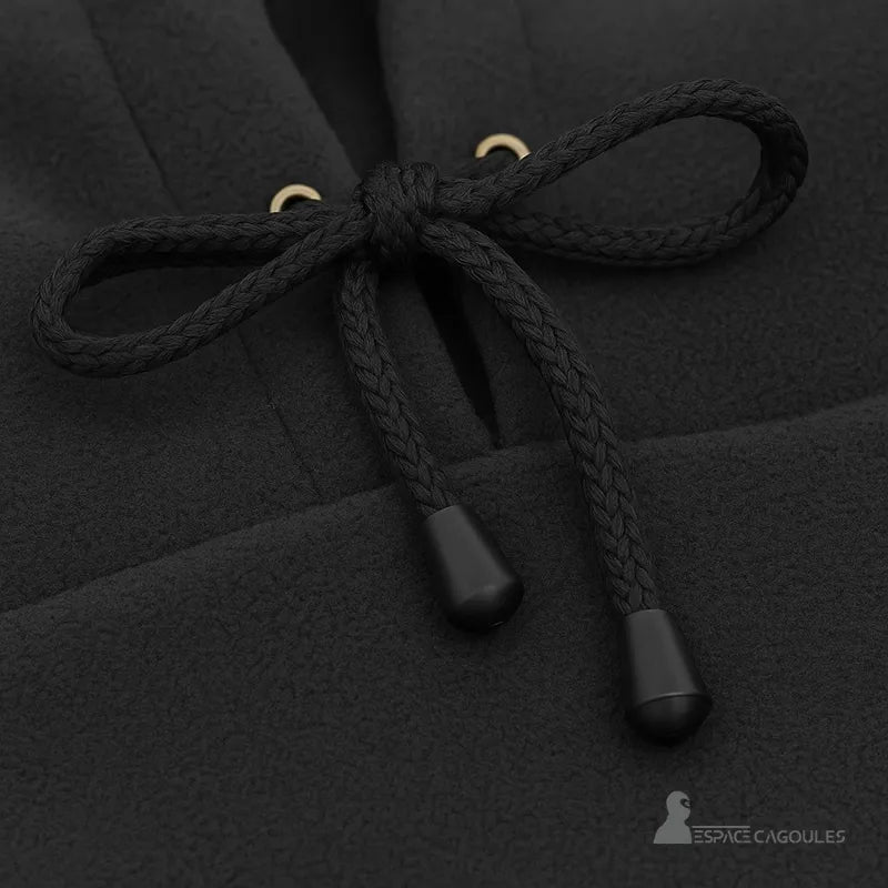 Cagoule Capuche noire avec gros plan sur les cordons croisés et œillets dorés, tissu polaire visible.