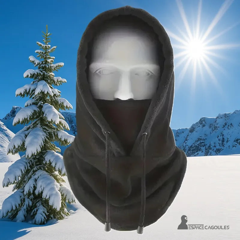 Cagoule Capuche noire portée en extérieur avec fond montagneux enneigé et soleil éclatant, idéale pour le ski ou la randonnée hivernale.