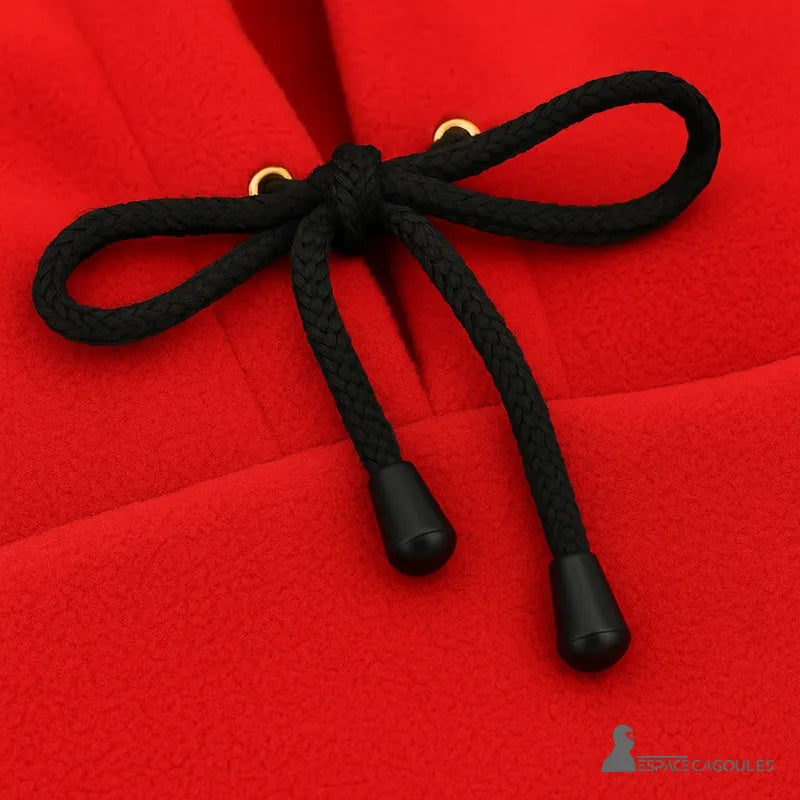 Balaclava Red hood zoomed in on the black drawstring, finishing details and metallic eyelets on a fleece background