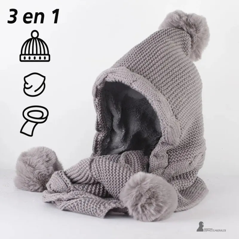 Cagoule écharpe tricot gris 3 en 1 avec pompons en fausse fourrure, bonnet capuche et écharpe intégrée pour femme, présentée sur fond blanc – Espace Cagoules