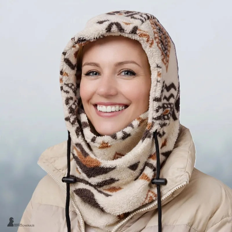 Femme souriante en forêt enneigée portant la cagoule en polaire PolarHead écru, masque baissé en tour de cou - Espace Cagoules