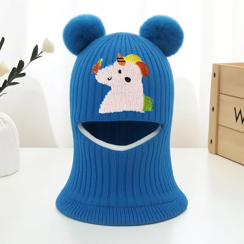 Cagoule enfant 4 ans bleue en laine, avec une ouverture pour le visage, oreilles rondes et dessin licorne colorée.