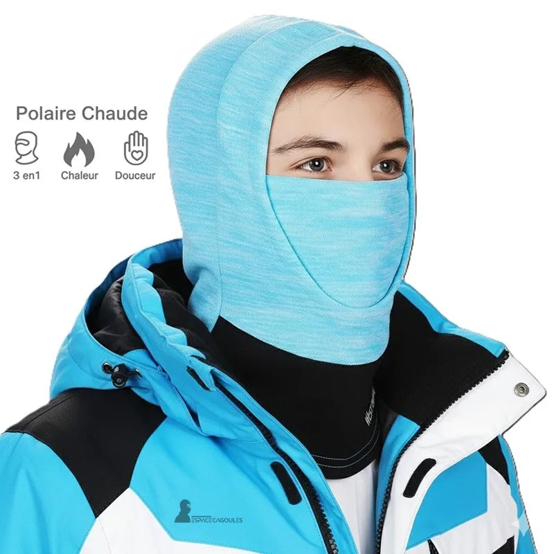 Blå balaklava för barn som bärs av en pojke i en blå och vit skidjacka, som framhäver den varma fleecen och andningsförmågan – Espace Cagoules