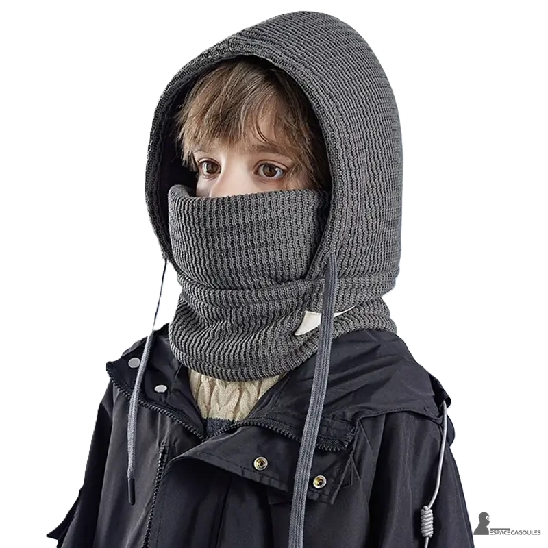 Cagoule enfant hiver avec tour de cou gris foncé portée par un garçon en manteau noir capuche chaude couvrant le visage