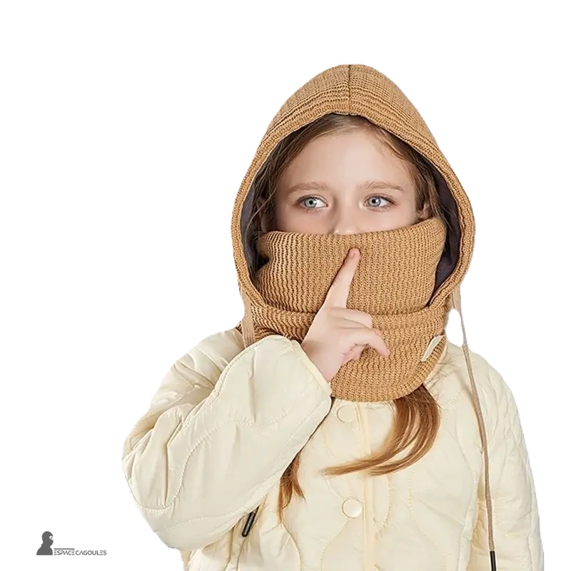 Cagoule enfant hiver avec tour de cou kaki portée par une fille en manteau beige clair capuche tricot couvrant bouche et nez