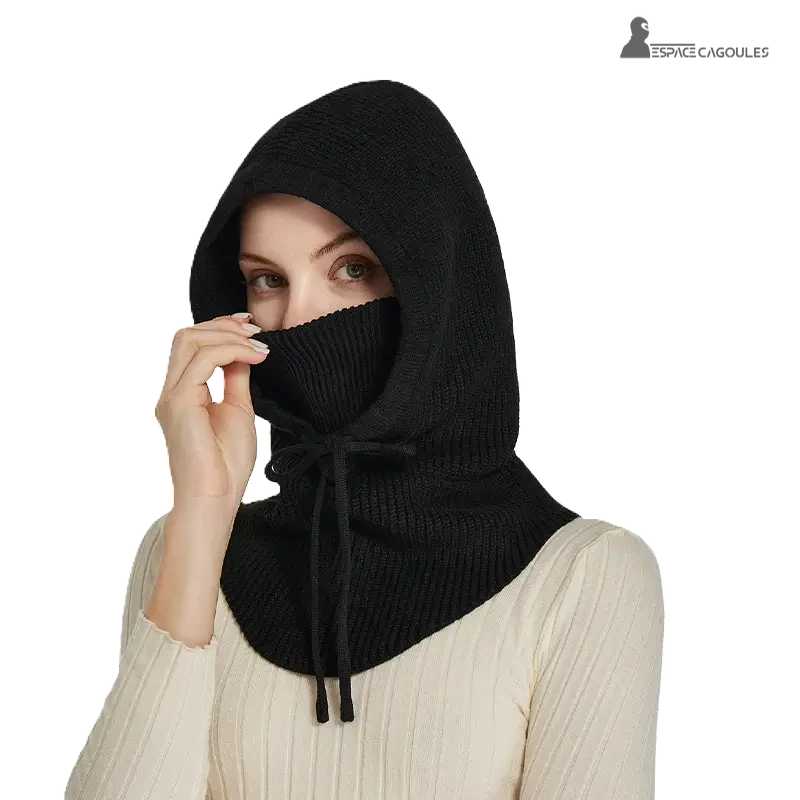 Cagoule Femme avec tour de cou intégré en maille noire, portée par une femme couvrant tête et cou, fond blanc isolé