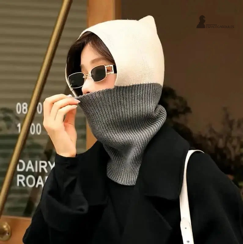 Cagoule femme chic beige et gris portée en extérieur, couvrant cou et tête contre le froid.