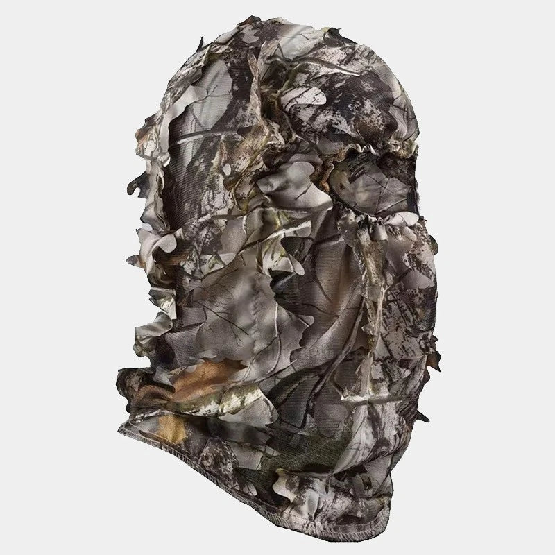 Camouflage net balaclava seen in profile, with a realistic pattern of foliage and branches, providing full coverage for optimal discretion in wooded environments. Perfect for hunting or wildlife viewing.