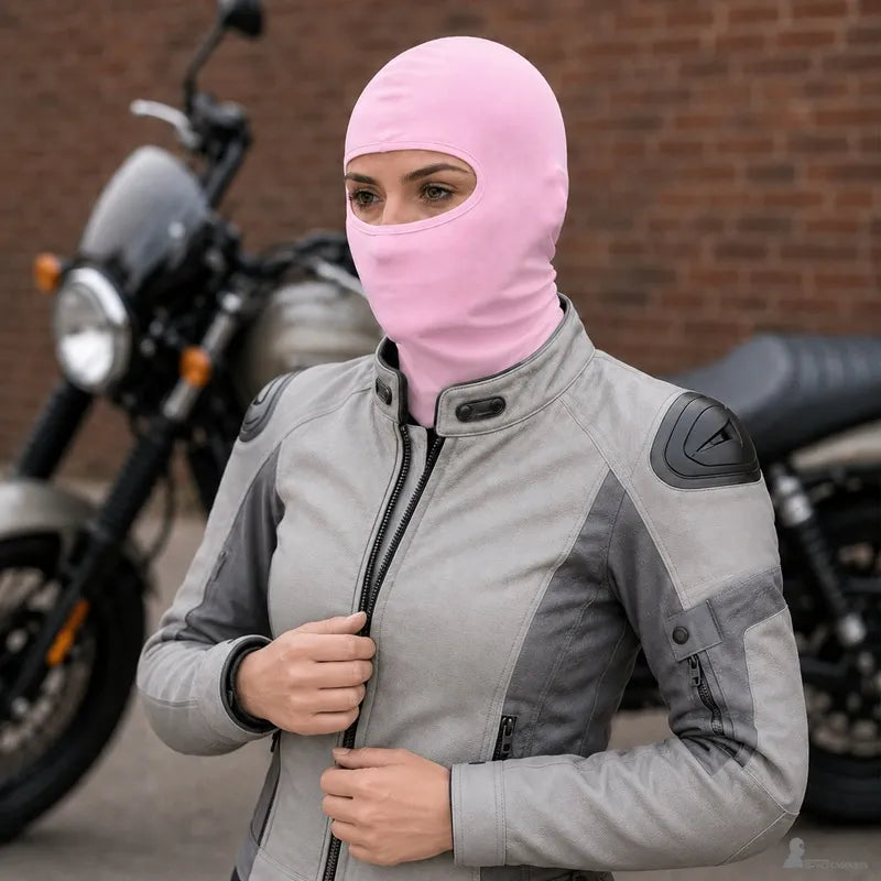 Motarde portant une cagoule fine moto rose devant une moto en ville - Espace Cagoules