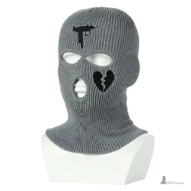 Cagoule gangster gris foncé en tricot avec broderies noires pistolet et cœur brisé, posée sur mannequin blanc