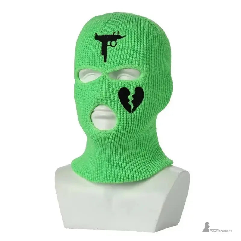 Cagoule gangster verte en tricot vif avec broderie noire pistolet et cœur brisé, présentée sur mannequin buste blanc