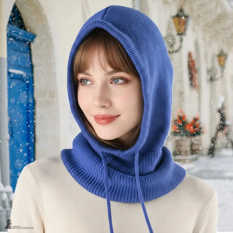 Passamontagna invernale donna – donna che indossa una Passamontagna di maglia blu reale, cappuccio aderente, decorazione innevata sullo sfondo - Spazio Passamontagna