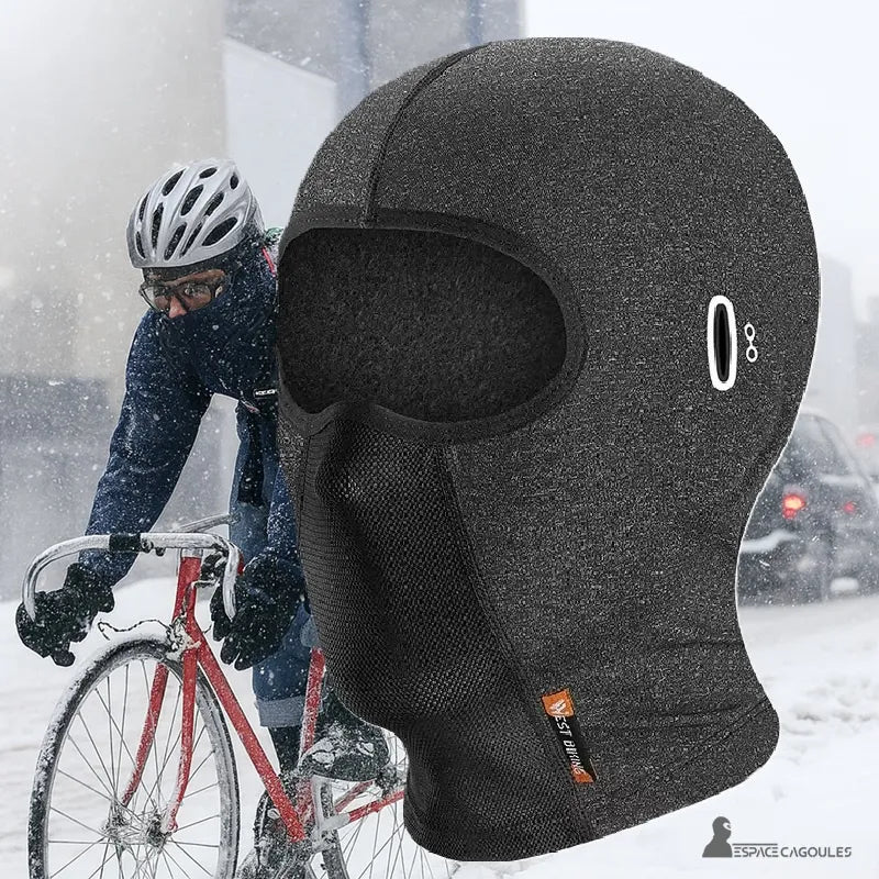 Cagoule hiver vélo noire coupe-vent en polaire portée par un cycliste sous la neige pour protection contre le froid hivernal