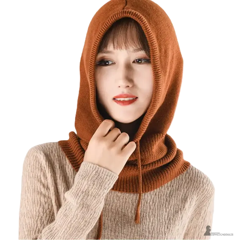 Passamontagna di lana color caramello indossato da una donna con un maglione beige, cappuccio con un cordino