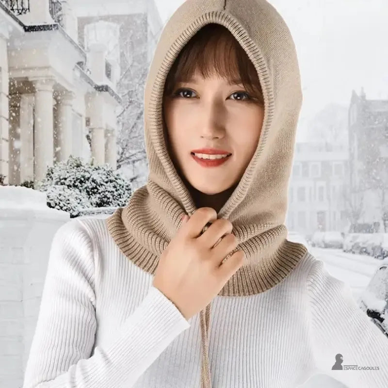 Cagoule laine femme kaki portée par une femme en extérieur avec fond enneigé urbain