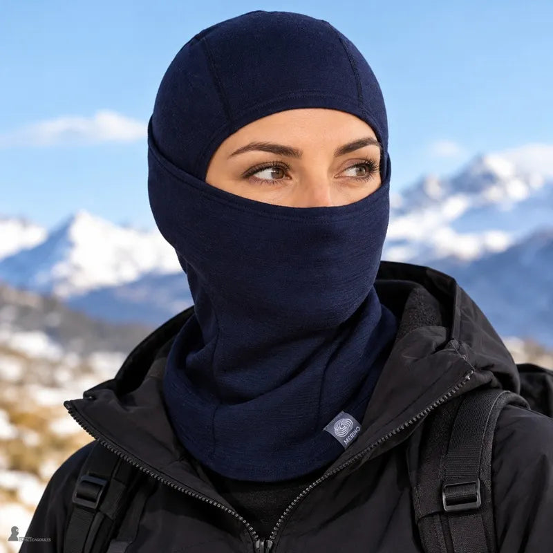 Femme portant la cagoule laine mérinos Ovis bleu roi qui couvre la tête, le visage et le cou, face aux montagnes enneigées - Espace Cagoules