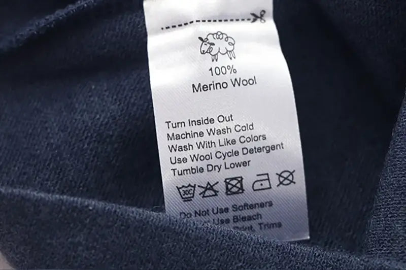 Close-up of the label of a merino wool cycling balaclava, showing the care instructions and high-quality composition