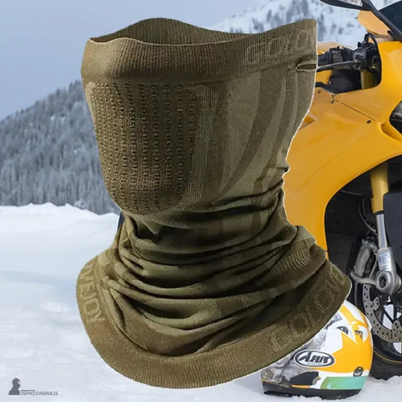 Kominiarka maska motocyklowa z zielonym khaki, z teksturowaną strefą ust i otworami na uszy, prezentowana przed żółtą motocyklą na śniegu - Espace Cagoules