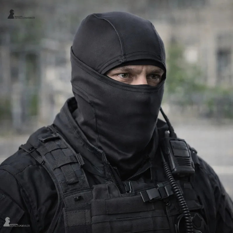 Homme portant la cagoule militaire noire avec un gilet tactique et une radio, seuls les yeux visibles - Espace Cagoules