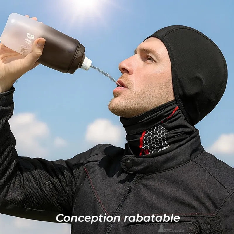 Cagoule moto anti transpiration portĂ©e par un homme buvant de lâeau en extĂ©rieur sous un ciel bleu, conception rabattable