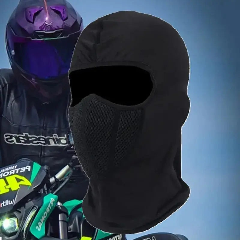 Cagoule Moto en Lycra noire portée par un motard équipé, casque aux reflets violets en arrière-plan. Protection intégrale du visage avec zone respirante en maille pour un meilleur confort et ventilation.