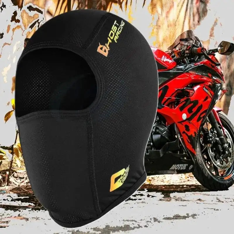Cagoule Moto en Soie noire ultra-légÚre avec ouverture faciale, posée devant une moto rouge sur un fond urbain. Conception respirante et ajustée pour une protection optimale sous le casque.