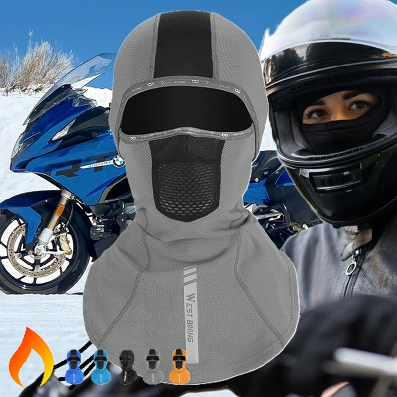 Women's motorcycle balaclava with long hair in grey, designed to protect against wind and cold, worn with a motorcycle helmet against a snowy landscape.