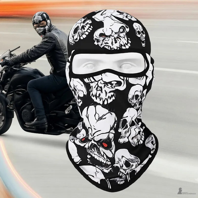 Motorcycle balaclava skull RoadReaper with a pattern of stacked white skulls worn, front view with a rider in motion in the background - Space Balaclavas.