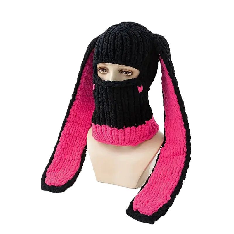 Black and pink rabbit ears balaclava on mannequin â A black ski balaclava with rabbit ears lined with bright pink is placed on a mannequin, perfect for an original and trendy look.