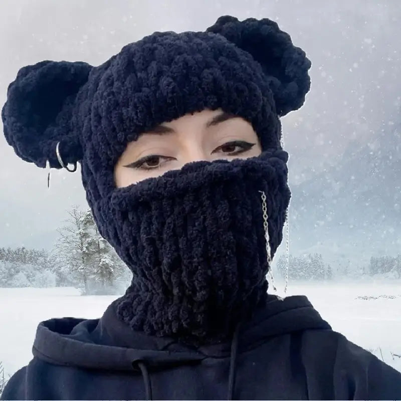 Schwarze Ohrkapuze, die in einer verschneiten Umgebung getragen wird, perfekt für Winteraktivitäten und kalte Umgebungen."