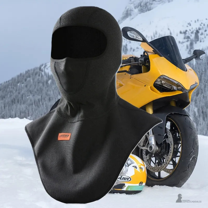Cagoule plastron noire pour moto en montagne enneigée avec moto sportive jaune en arrière plan